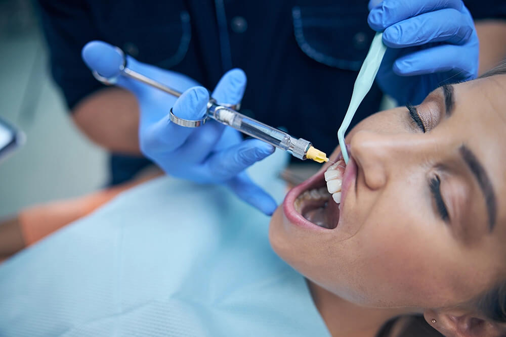 dentist-doing-injection-in-woman-gum-in-office